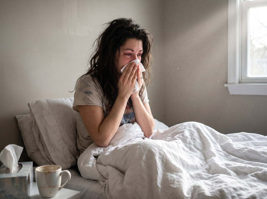 Mujer estornudando al despertar en la cama